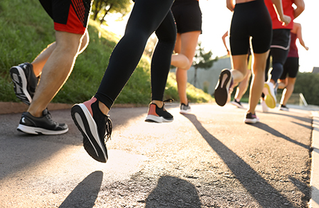 Group of people running outdoors on sunny day.