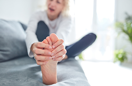 A woman rubbing her dry feet.