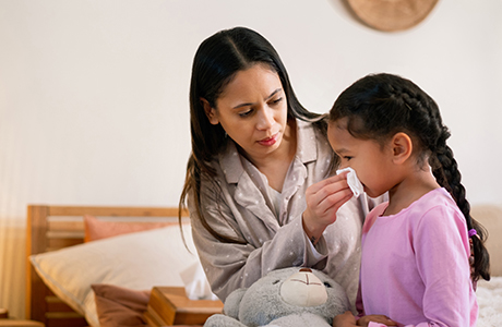 Mother helping her daughter stop a nosebleed 